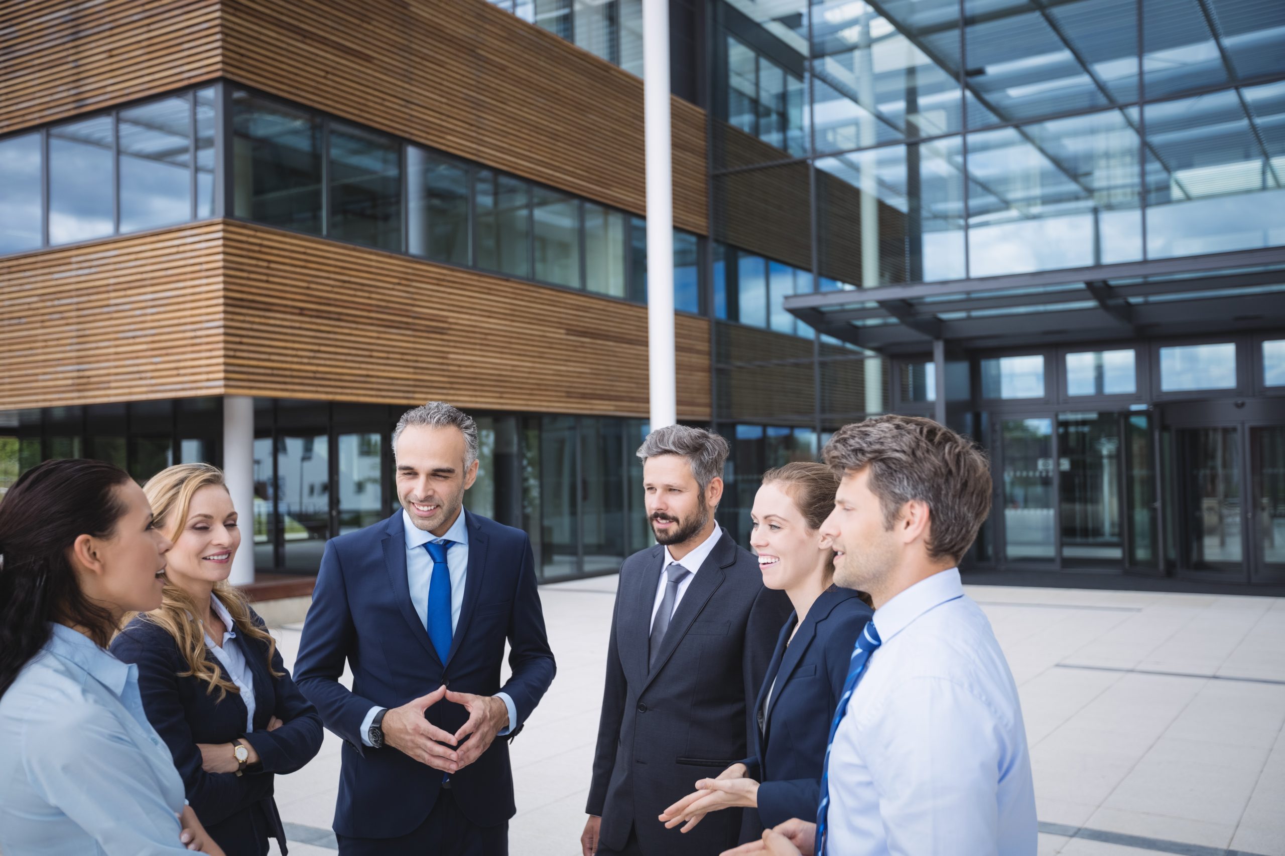 Business professionals discussing employment arrangements outside an office