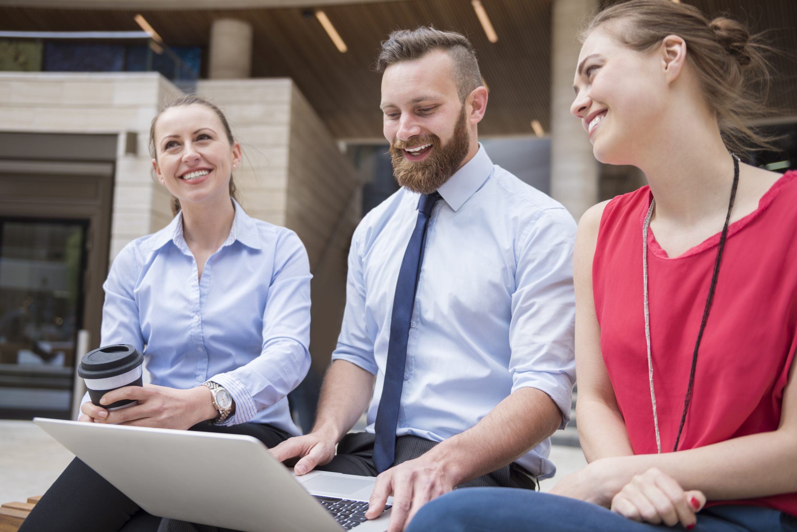 Employees speaking outside a modern office building
